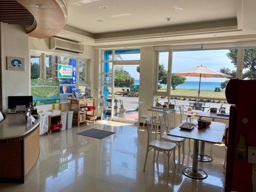 un ristorante con tavoli e sedie e vista sull'oceano di LoveSea 126 Beach Inn a Kenting