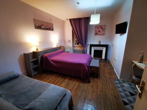a bedroom with a purple bed and a fireplace at Logis Hôtel & Restaurant Le Saint Savinien in Saint-Savinien