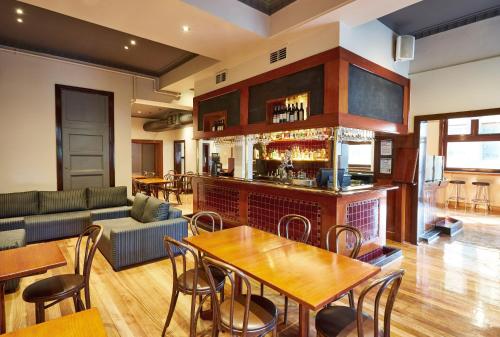 un soggiorno con bar arredato con tavoli e sedie di Hotel Sophia a Melbourne