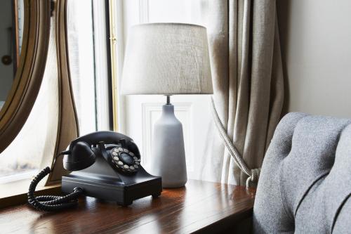a telephone sitting on a table next to a window at The Roseate Edinburgh - Small Luxury Hotels of the World in Edinburgh