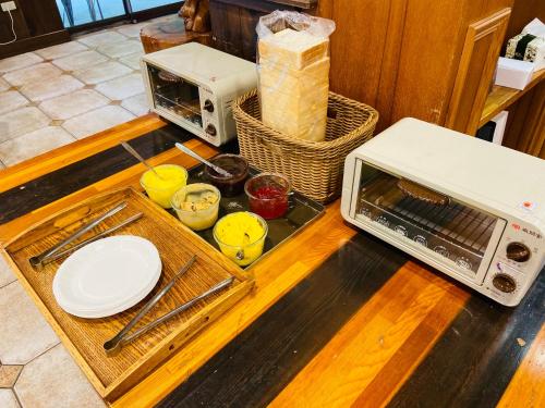 a kitchen counter with a microwave and plates on a table at Spring Ground Resort in Renai