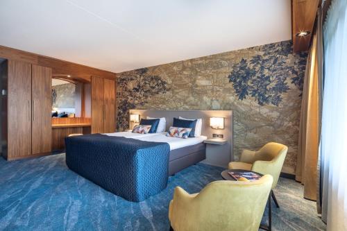 a hotel room with a bed and two chairs at Hotel van der Valk Wolvega-Heerenveen in Wolvega