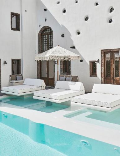 a room with four beds and a swimming pool at Winery Hotel 1870 in Fira