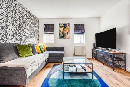 a living room with a couch and a flat screen tv at 3 Bedroom Townhouse near South Park Oxford - close to city centre ! in Oxford