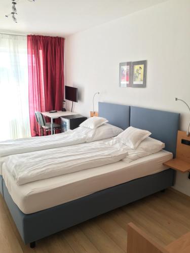 a bedroom with a large bed with a desk and a table at Hotel Bairischer Hof in Marktredwitz