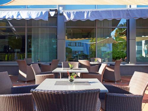 an outdoor patio with tables and chairs and windows at Novotel Poznań Malta in Poznań