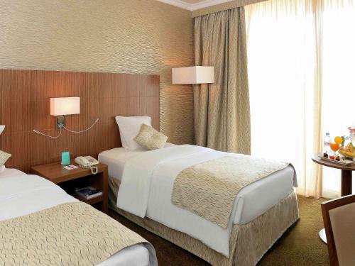 a hotel room with two beds and a phone at Treffen House Doha - Souq Waqif and next to Msheireb Metro Station in Doha