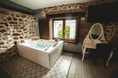 a bathroom with a tub and a table and a sink at Posada La Corralada in Pámanes