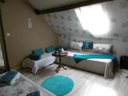 Saint-Julien-sur-CherにあるChambres d'hotes du Moulinのベッドルーム1室(ベッド2台、テーブル、窓付)