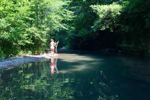 a woman walking in the water in a river at Les pieds dans l'eau - Gîte de L'olivier - Plage privée in Blacons