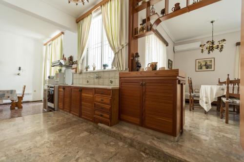 uma grande cozinha com armários de madeira e uma mesa em villa nicol em Corinto