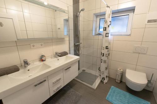 a bathroom with a sink and a shower and a toilet at Ferienwohnungen Angermaier in Flattach