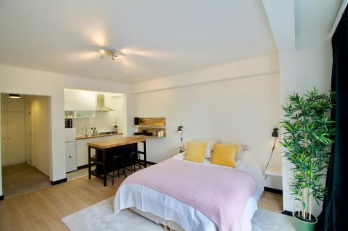 ein Schlafzimmer mit Bett und eine kleine Küche in der Unterkunft Splendid & cosy studio - perfect location 'Stephanie-Louise area' in Brüssel