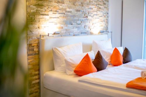 a bedroom with two beds with orange and white pillows at Mein Appartement Hürth Köln in Cologne