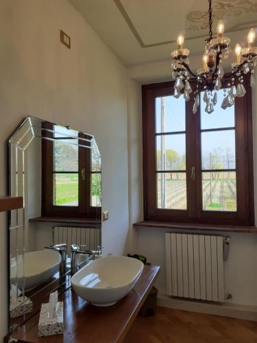La salle de bains est pourvue de 2 lavabos et d'un grand miroir. dans l'établissement B&B Cascina in Franciacorta, à Cologne