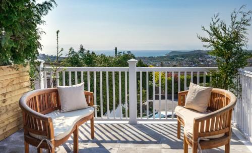 two chairs on a balcony with a view of the ocean at Rockleigh Place in St Austell
