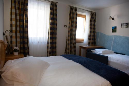 a bedroom with two beds and a window at Baita Scaia in Cogolo