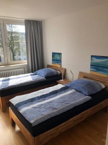 two twin beds in a room with a window at Micha's Ferienwohnung in Duisburg