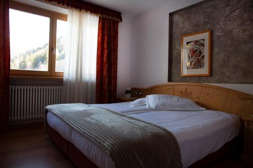 a bedroom with a bed in front of a window at Baita Scaia in Cogolo