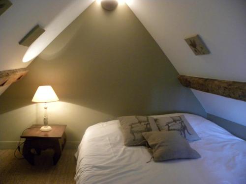 a bedroom with a bed and a table with a lamp at Domaine du Gué du Roi in Cléry-Saint-André