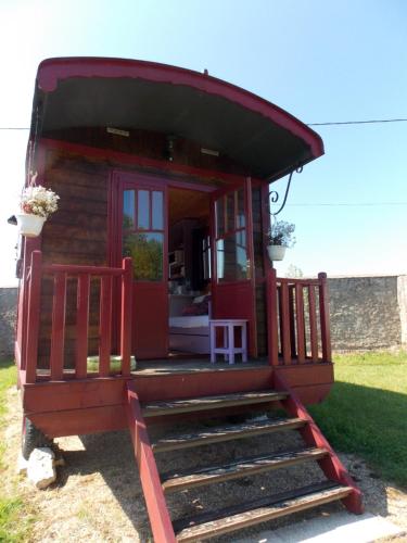 a small cabin with a red door and stairs at Domaine du Gué du Roi in Cléry-Saint-André