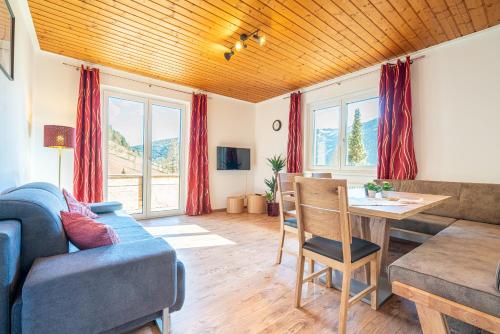 a living room with a blue couch and a table at Berghaus Traumblick in Bad Kleinkirchheim