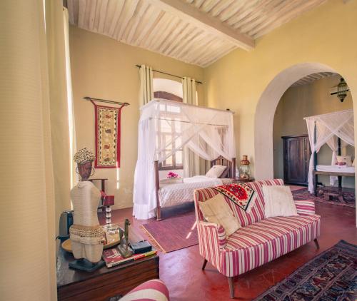 une chambre avec un lit, un canapé et une chaise dans l'établissement Terraço das Quitandas Design Accommodation-AL, à Île de Mozambique