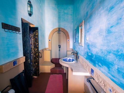 Terraço das Quitandas Design Accommodation-AL في جزيرة موزامبيق: حمام مع حوض وحائط ازرق