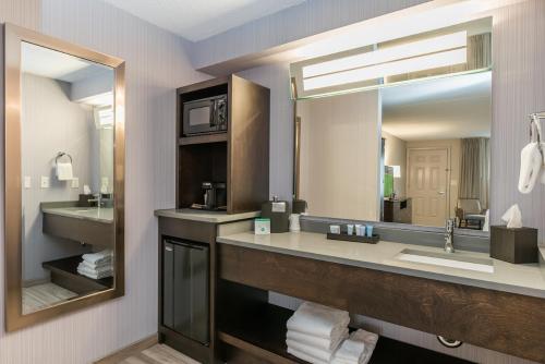 a bathroom with a sink and a large mirror at Rockport Inn and Suites in Rockport