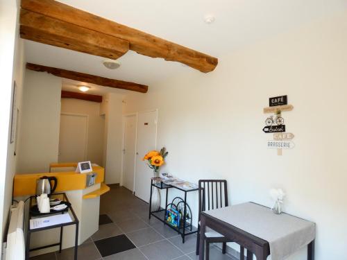 a kitchen and dining room with a table and chairs at Hôtel Restaurant le clos de l 'Ancien Pressoir in Commes