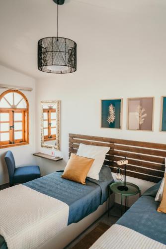 a bedroom with two beds and a chair at Coralsunset Property Management Ltd in Coral Bay
