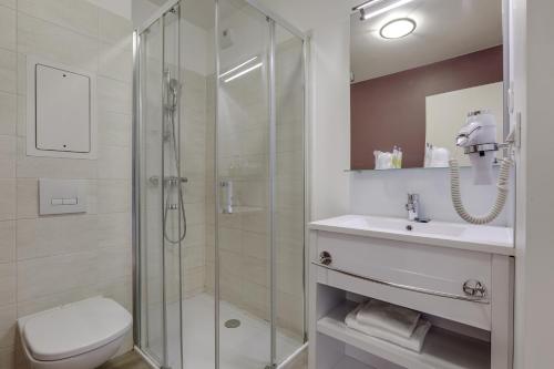 a bathroom with a shower and a toilet and a sink at All Suites Appart Hôtel - Choisy-le-Roi in Choisy-le-Roi