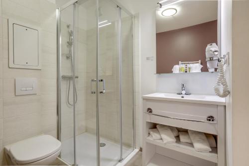 a bathroom with a shower and a toilet and a sink at All Suites Appart Hôtel - Choisy-le-Roi in Choisy-le-Roi