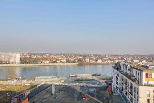 a view of a river with buildings and a city at All Suites Appart Hôtel - Choisy-le-Roi in Choisy-le-Roi