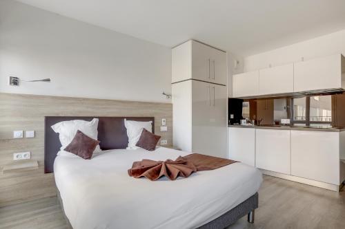 a bedroom with a large bed with white cabinets at All Suites Appart Hôtel - Choisy-le-Roi in Choisy-le-Roi