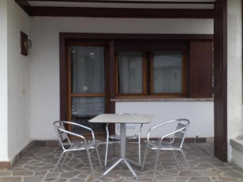 皮耶韋迪卡多雷的住宿－Habitat Dolomiti-Cadore，天井上的桌子和两把椅子