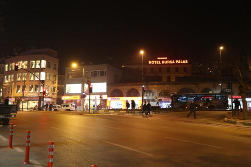 a city street at night with people crossing the street at Bursa Palas Hotel in Bursa