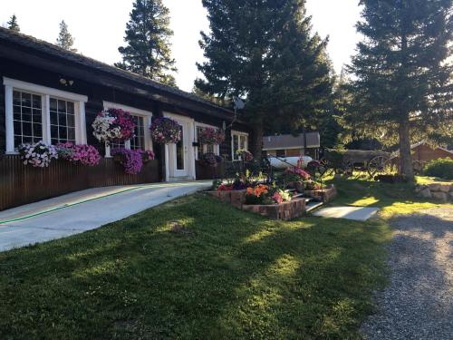 une maison avec des fleurs sur son côté dans l'établissement Antlers Lodge, à Cooke City