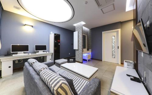 sala de estar con sofá y TV en Urban Stay Hotel, en Gwangju