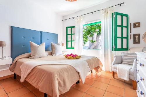 a bedroom with a bed with a bowl of flowers on it at Casajardin in Playa Honda