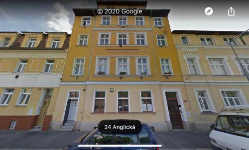 a yellow building with a car parked in front of it at HARMONIA II Apartment in Františkovy Lázně