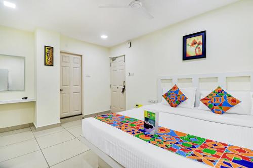 een kamer met 2 bedden en kleurrijke kussens bij FabHotel Colors Service Apartment in Chennai