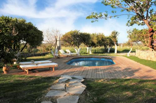 a pool in a yard with a bench and a table at Archontiko tis Irinis in Ádhele