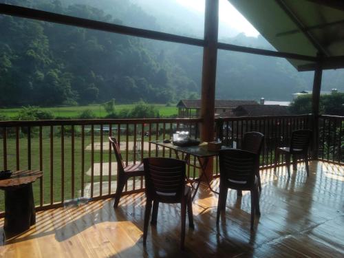 a patio with a table and chairs on a balcony at Tran Xuan Homestay Ba Be Village in Ba Be