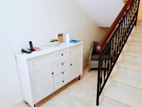 a white dresser in a room with a staircase at Ralux apartman Tivat in Tivat