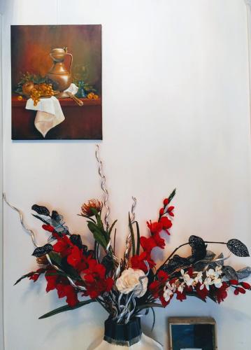 Eine Vase mit Blumen auf einem Tisch mit einem Gemälde in der Unterkunft Markermeerlogies in Bovenkarspel