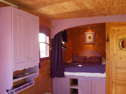 a bedroom with a bed in a wooden cabin at Domaine du Gué du Roi in Cléry-Saint-André