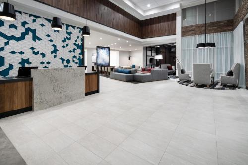 un hall de bureau avec une réception et des chaises dans l'établissement Hyatt Place Bakersfield, à Bakersfield