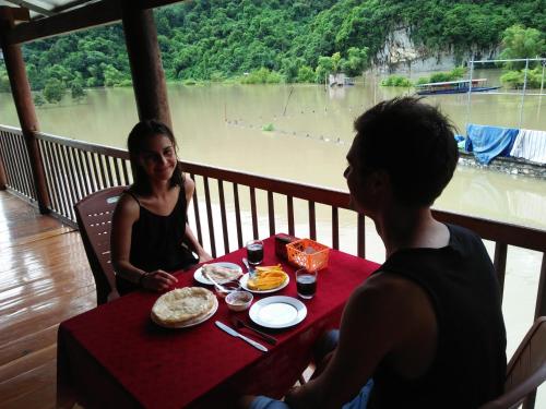 a man and a woman sitting at a table with food at Tran Xuan Homestay Ba Be Village in Ba Be