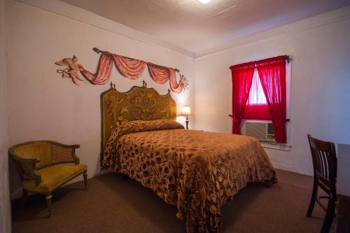 a bedroom with a bed and a red window at Amargosa Opera House & Hotel in Death Valley Junction